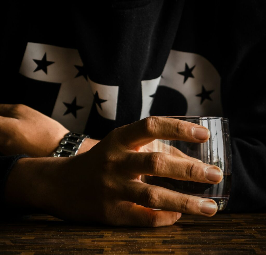hands holding glass water desk
