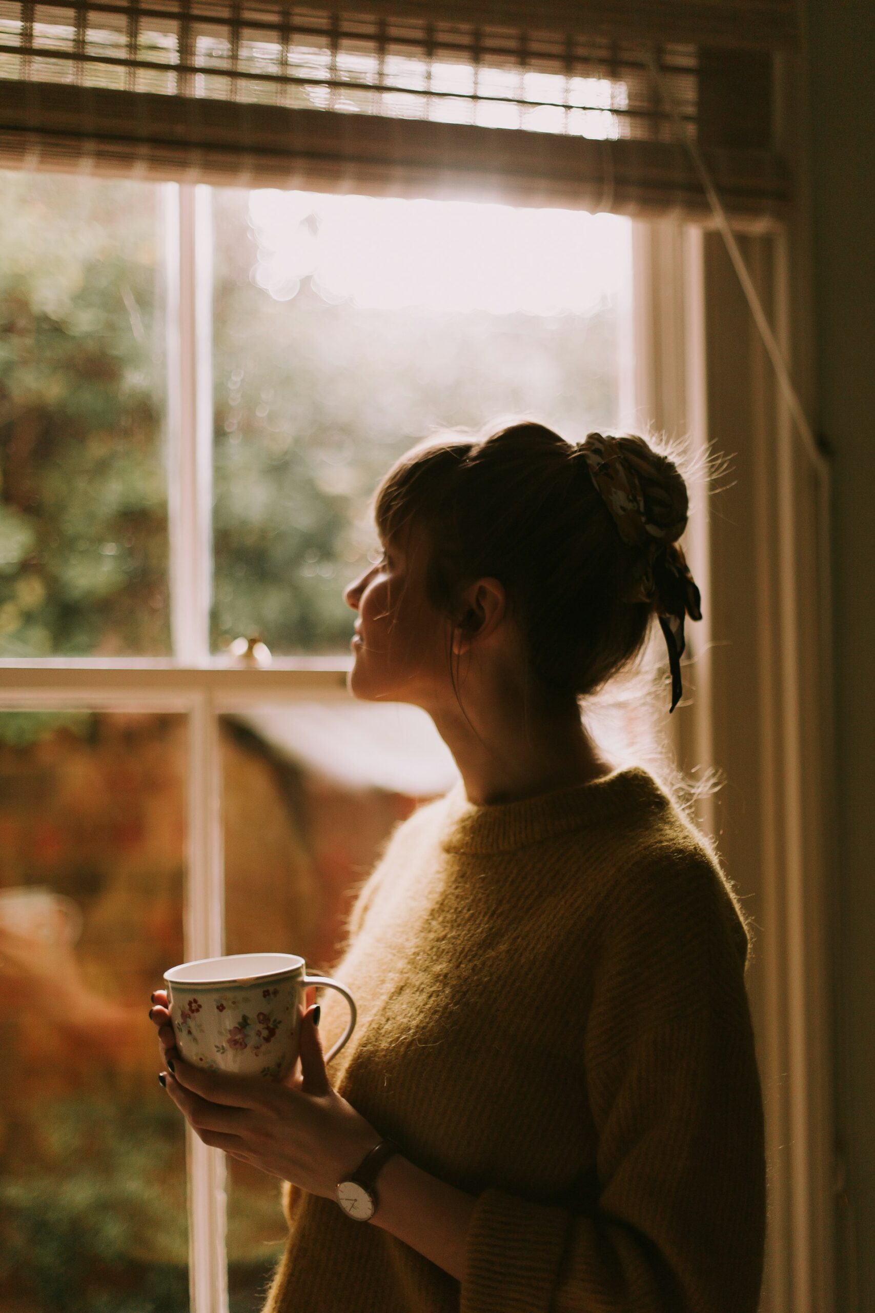 person drinking coffee cozy window morning