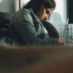 person alone in coffee shop looking thoughtful