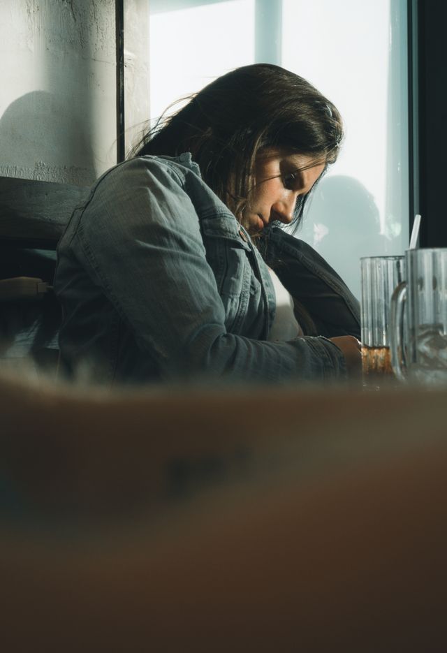 person alone in coffee shop looking thoughtful