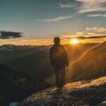 person standing sunrise mountain