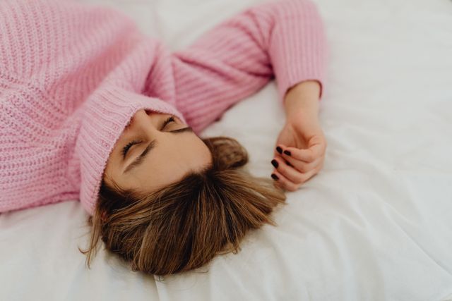 person lying flat bed eyes closed relaxation