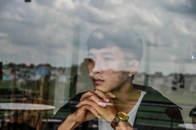 person reflection window thoughtful
