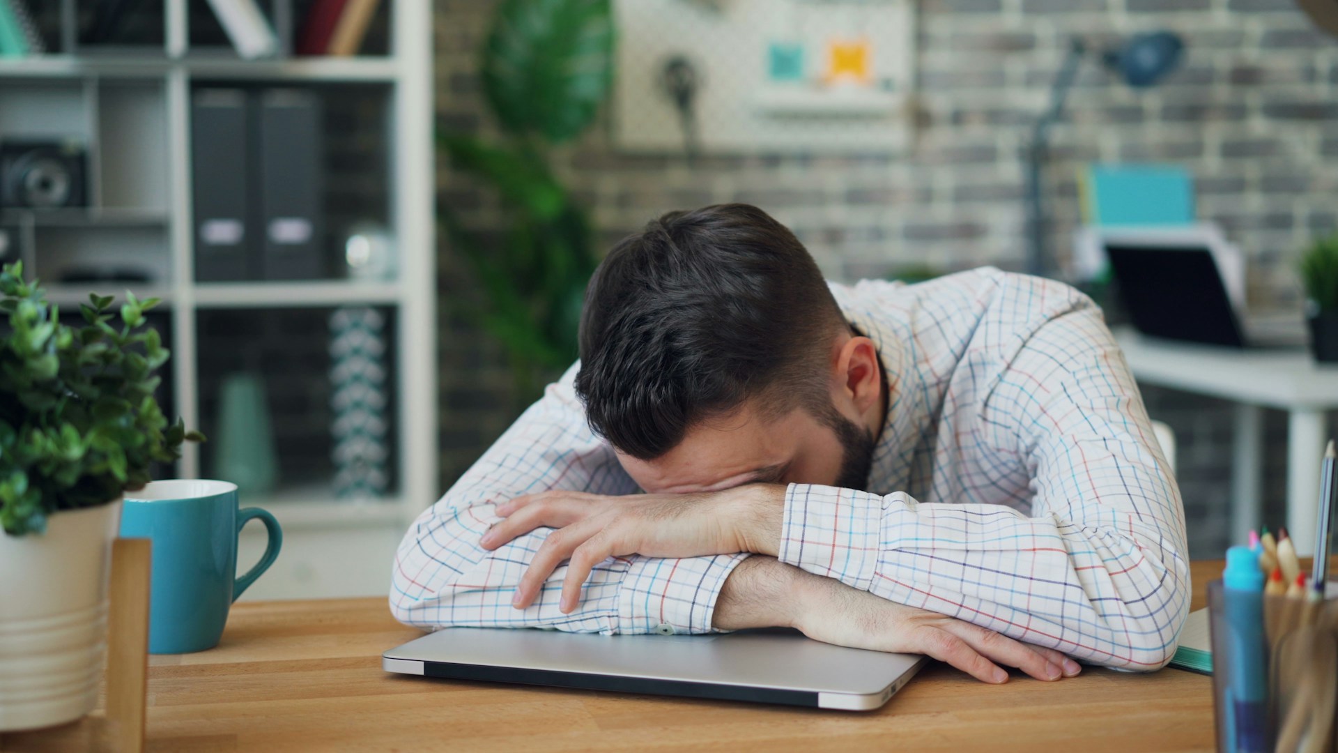tired person working at desk laptop
